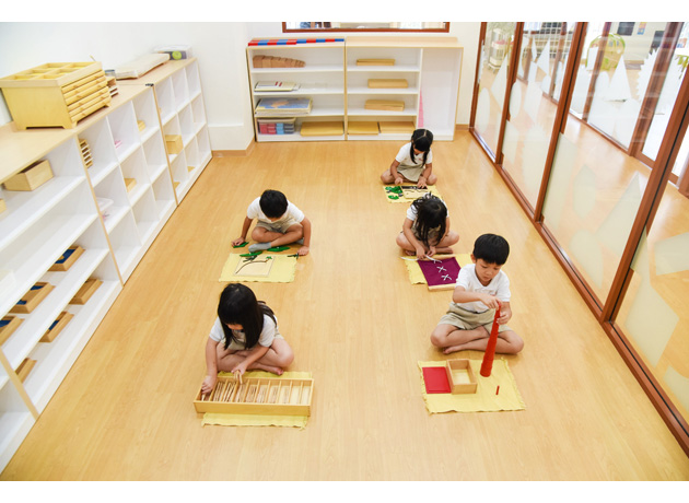 木製の玩具を使用したモンテッソーリモンテッソーリメソッドで学ぶ子供達